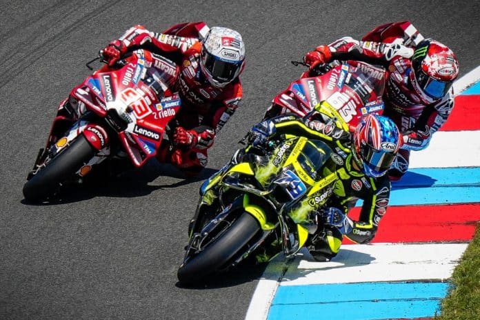 01_2026_09_OGURA_TSJ__preview Drie MotoGP-coureurs nemen een bocht op het circuit, met een gele Aprilia voorop en twee rode Ducati's erachter
