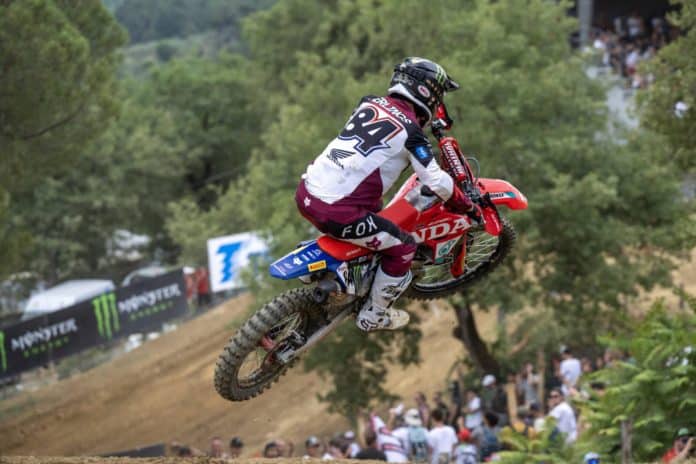 Jeffrey Herlings_preview Jeffrey Herlings met rugnummer 84 op een Honda springt hoog boven een zandheuvel tijdens een wedstrijd met publiek op de achtergrond
